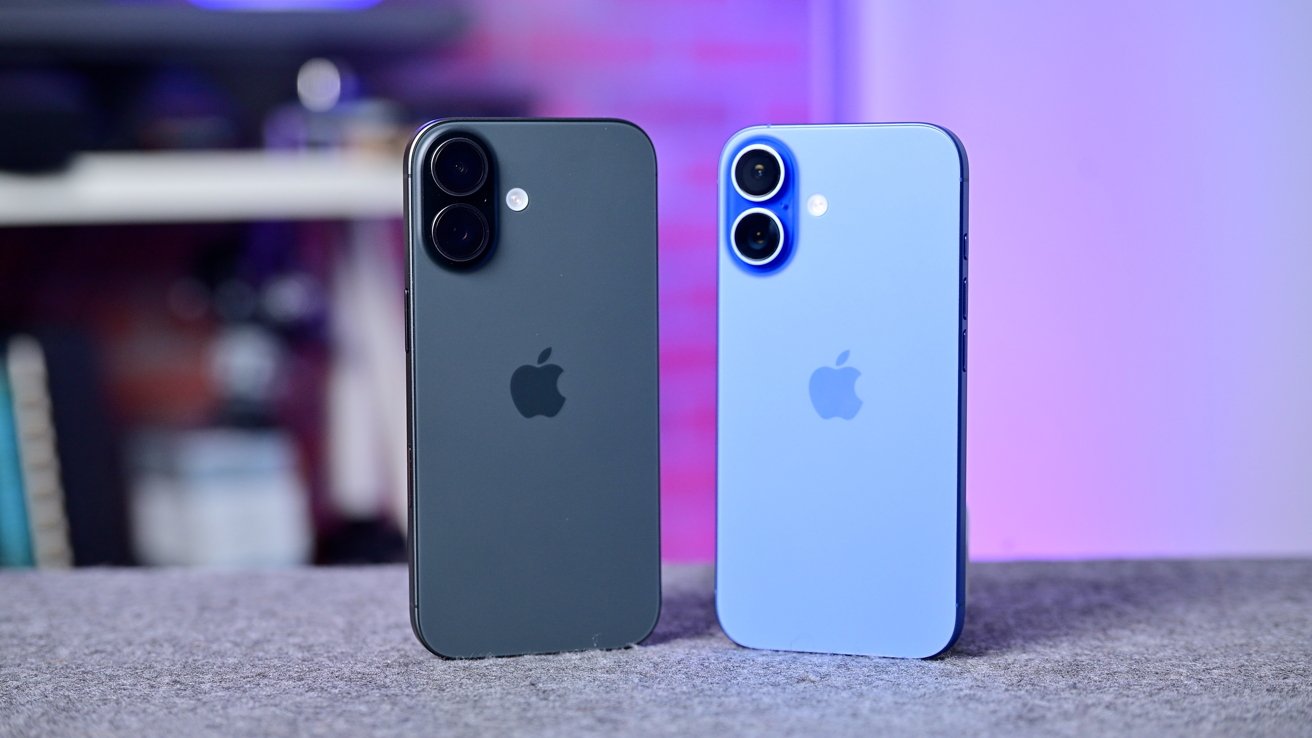 Two Apple smartphones standing upright on a gray surface, one dark gray and one light blue, showing their backs with dual camera lenses and Apple logos against a blurred colorful background